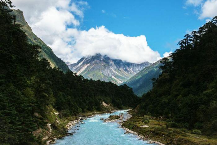 A remarkable view of cloud capped hills, greenery, and the river