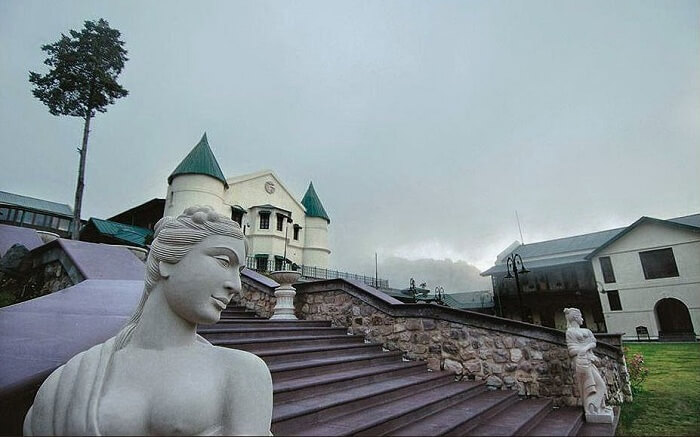 Striking statues and the atmospheric turrets of the Savoy on a misty day in Mussoorie