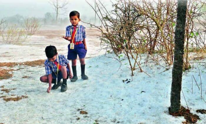 Two school kids playing with snow in Lambasingi