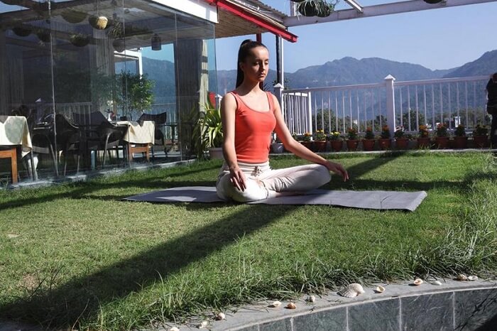 A tourist takes a yoga-cum-meditation session at the Ell Bee Resort in Rishikesh
