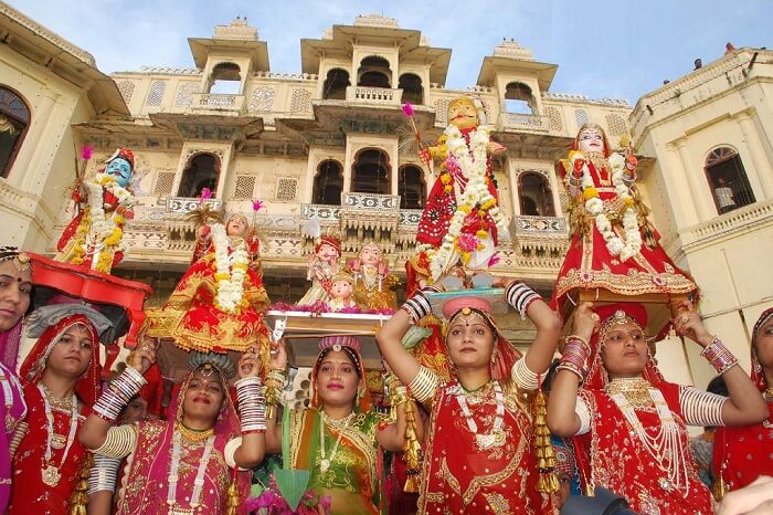Devotees carrying idols of the gods and goddesses during the Mewar festival