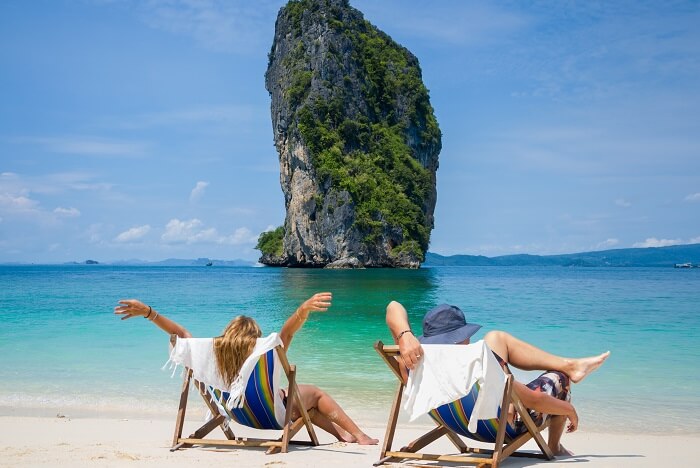 A couple relaxing on a beach in Thailand