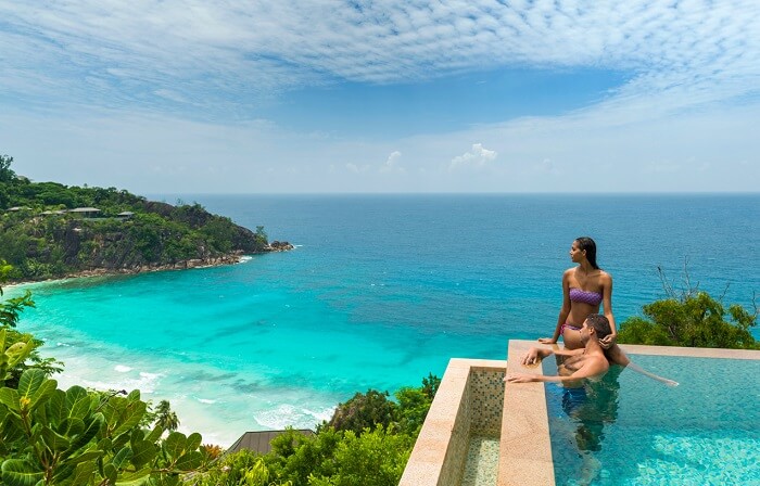 A lovey honeymooning couple gazing off at the beauty of Seychelles