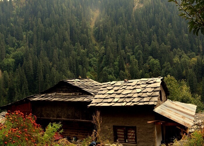 A rustic village home with a backdrop of forests slightly ahead of Kalga