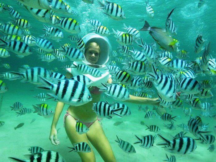 a girl enjoying undersea walk in andaman among sea fishes