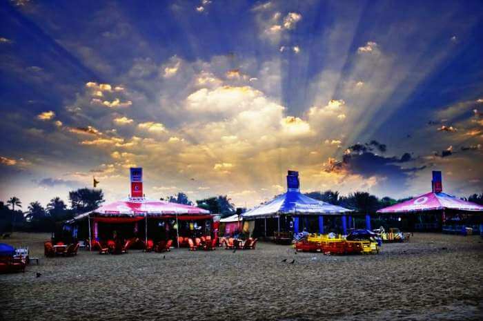 Dramatic skies and colorful shacks at Calangute beach in Goa
