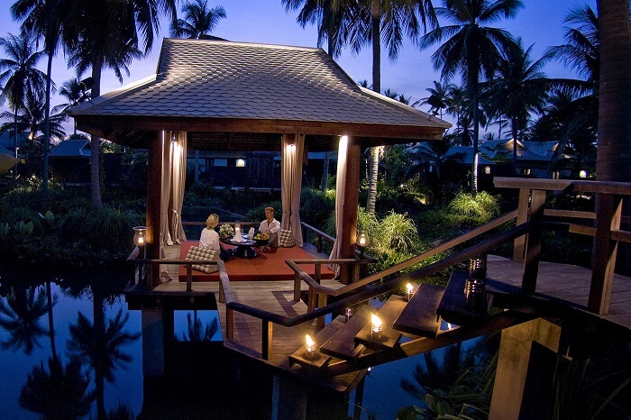 A couple having dinner by the swimming pool at the Anantara Mai Khao Phuket Villas