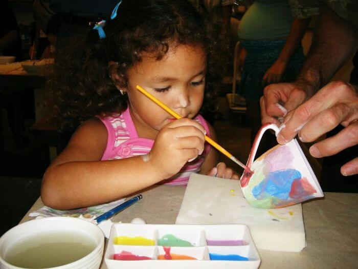 A girl trying her hand at a paint-a-pot workshop