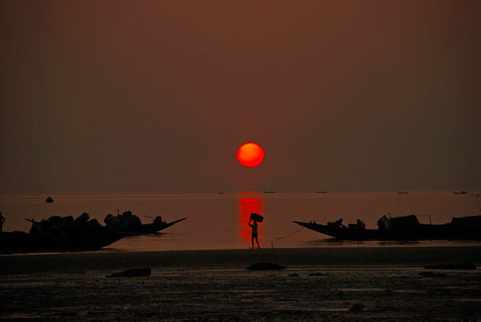 Sun sets on Bay of Bengal at Frasergunj as fishermen return home from the sea