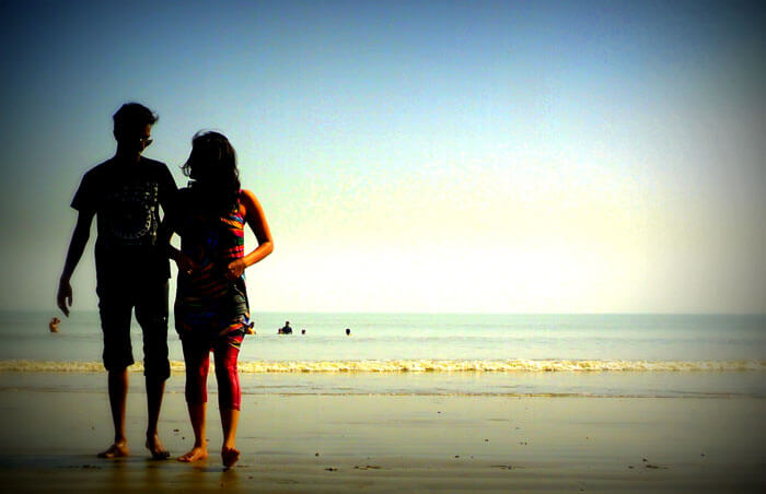 A couple walks on the serene beach at Junput near Kolkata
