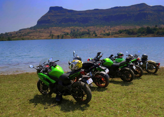 Bikes stand on the banks of the Vaitarna reservoir