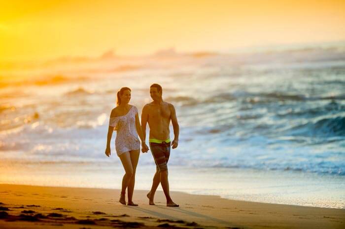 A couple taking an evening walk on the beach of Kauai, Hawaii