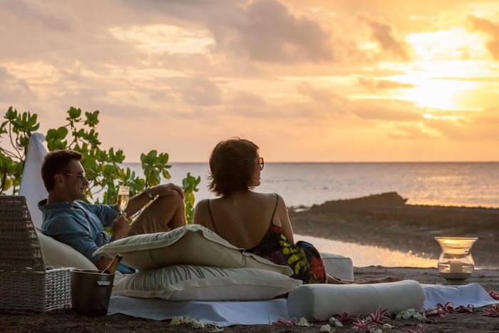 A couple relaxing on the beach at The Seychelles