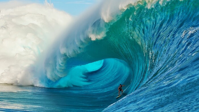 A man surfing on a gigantic wave