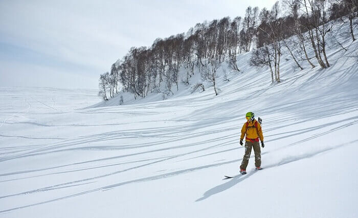 A man takes stance before snowboarding in Gulmarg