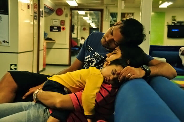 A couple and their baby taking a quick nap during a stop over