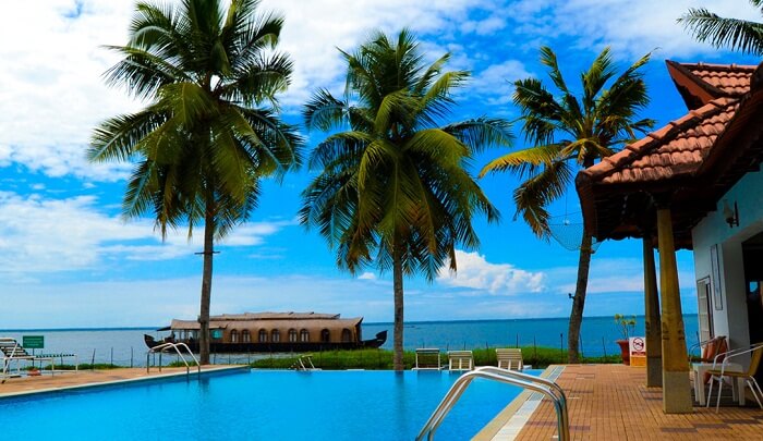 A view of the pool and the house boat in lake at Backwater Ripples Resort