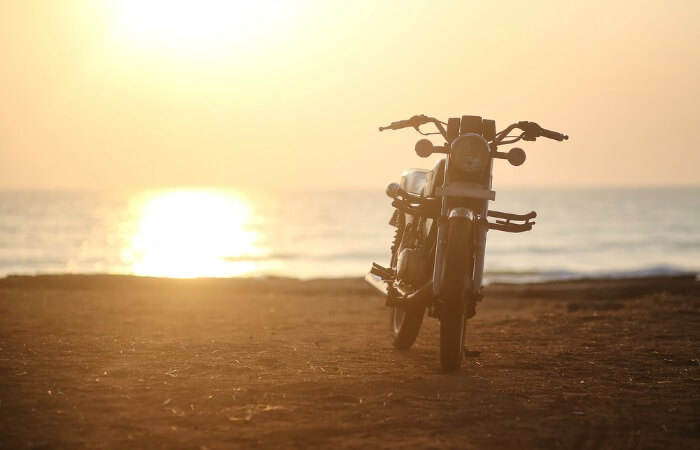 a lone bike on the beach on a road trip from mumbai to goa
