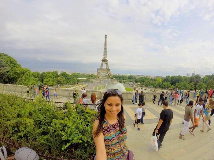 Leena in the background of the Eiffel Tower in Paris
