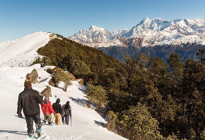 A small group of trekkers on their trek to Brahmatal with Mt Trishul and Mt Ghunti in the backdrop