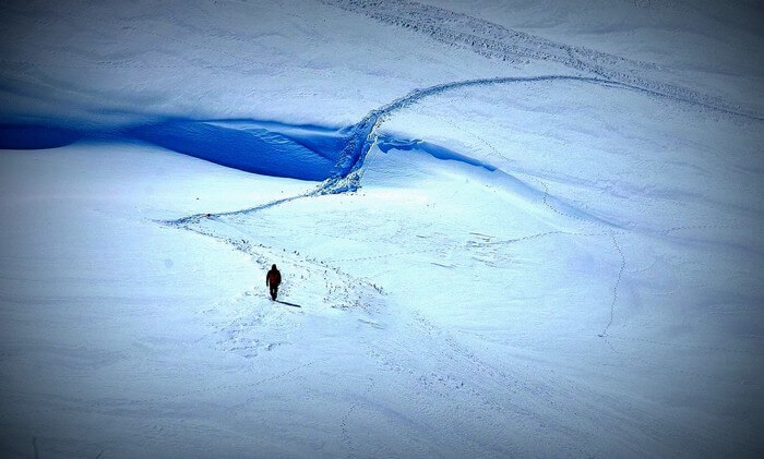 A man walking in the wide snow slope on the Roopkund trek
