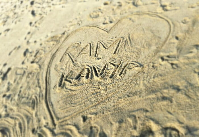 The names of Kavya and Ram on the beach