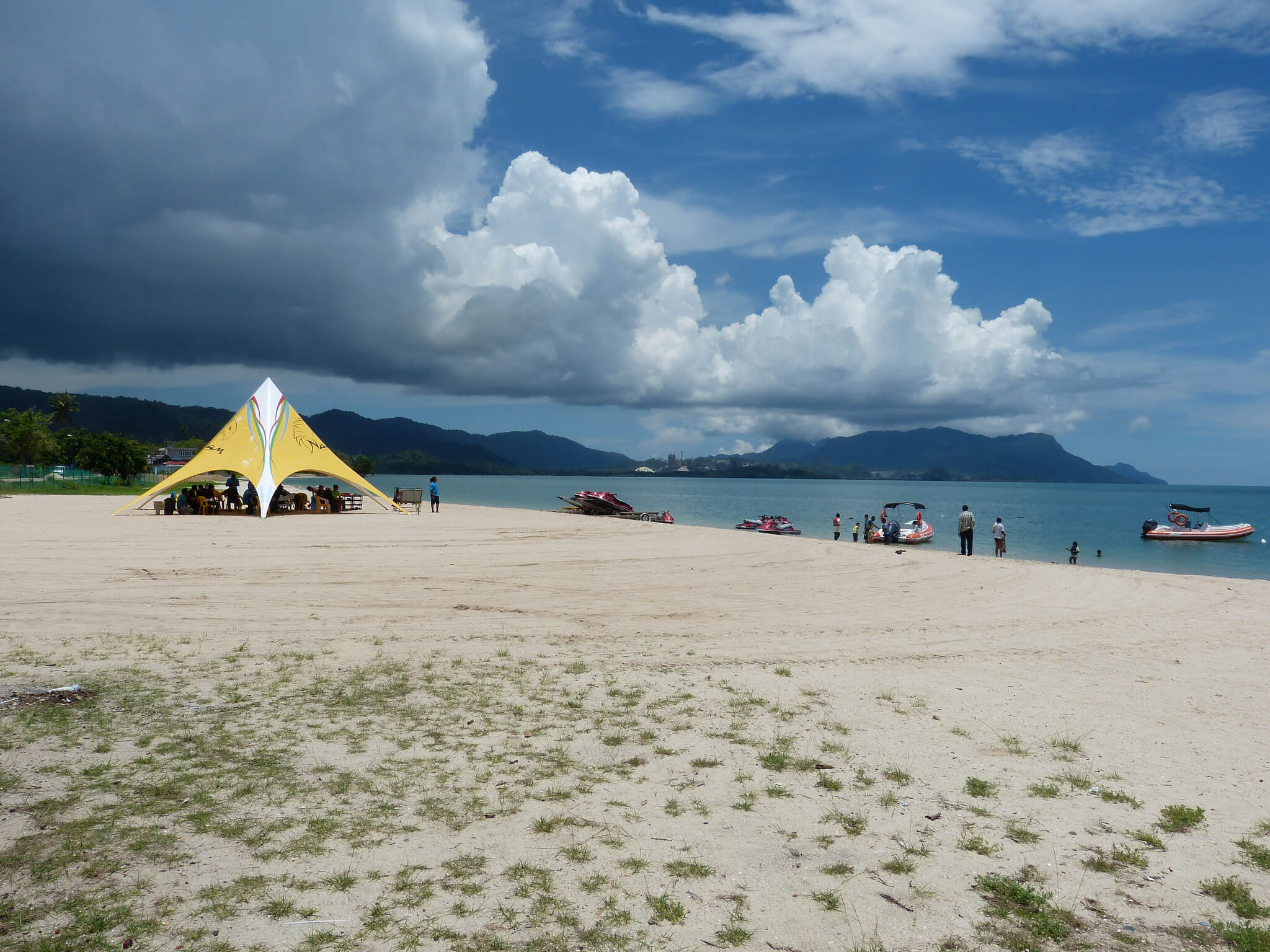 Tourists wait in a tent at Tanjung Rhu Beach for their turn to take a speed boat ride in the sea