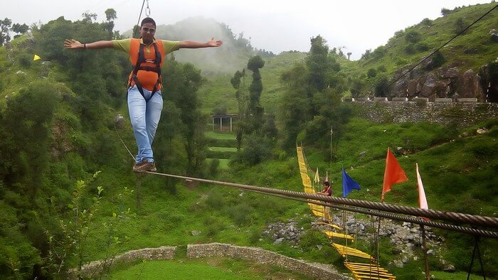 An adventure enthusiast tries to balance on the skywalk