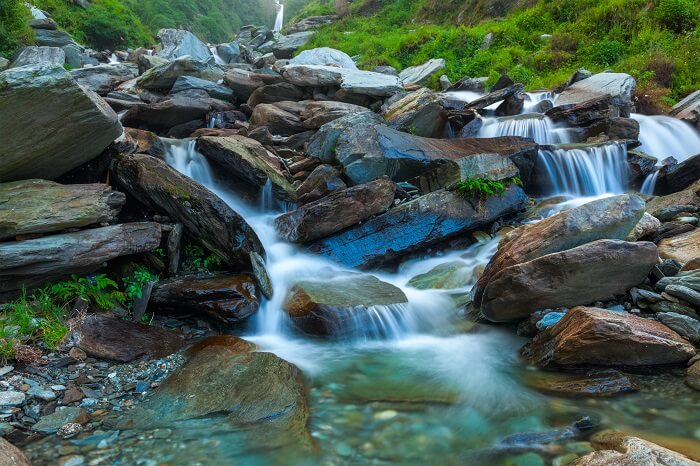 Milky white water cutting through the rocks at Bhagsunag Waterfall - one of the most popular tourist attractions in Dharamshala