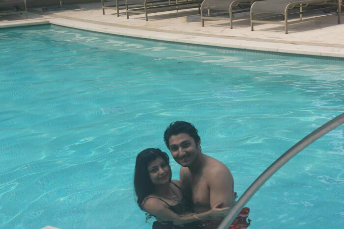 Mitula and his wife take a swim in the pool of their resort