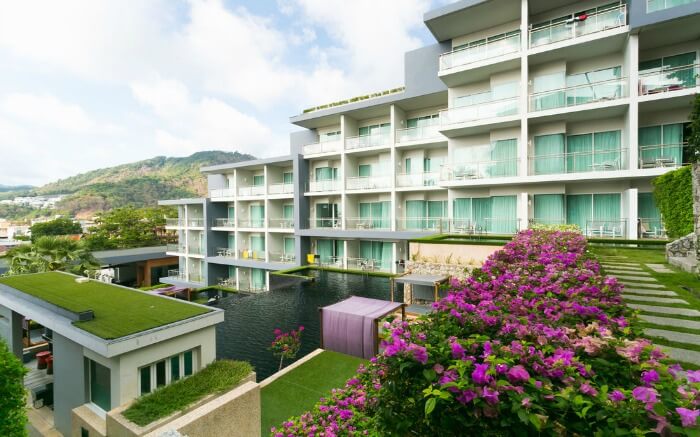 Beautiful flowers, grass and pool adorning the Sugar Palm Hillside Hotel