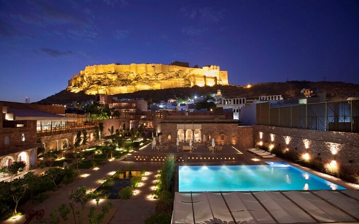 A night shot of the swimming pool at Rass Hotel with the Mehrangarh Fort in the backdrop