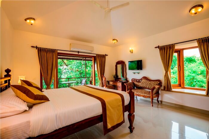 A bedroom with a garden view of Highland Heritage Goa
