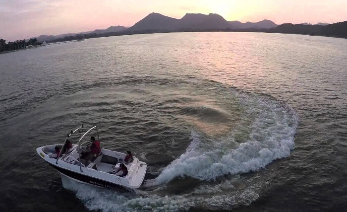 A couple of tourists enjoying the thrills of motor boating in Rajasthan at Fateh Sagar Lake