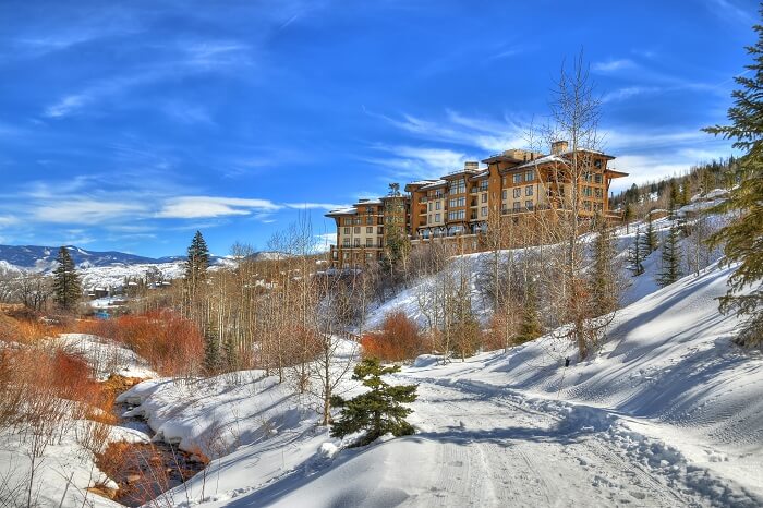 Beautiful colorful landscape in Snowmass - a river under a ski resort surrounded by trees in Aspen
