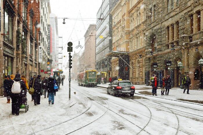A treetway in Finland with cars and a tram passing through