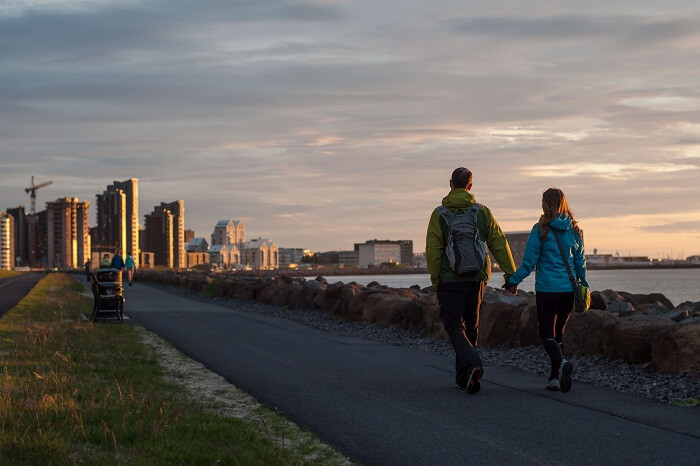 Happy sporty couple walking through the ocean coast in Reykjavik