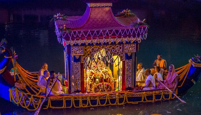 Priests carry the idols of Gods and Goddesses in a boat in the river Ganga on the occasion of Kartik Purnima