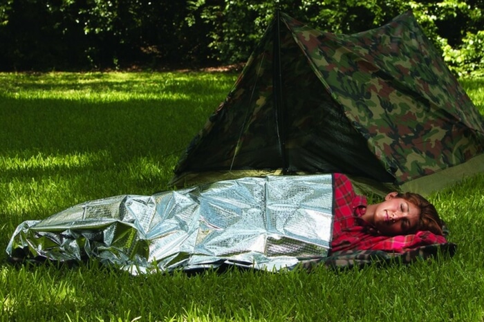 A traveler sleeping in a thermal blanket