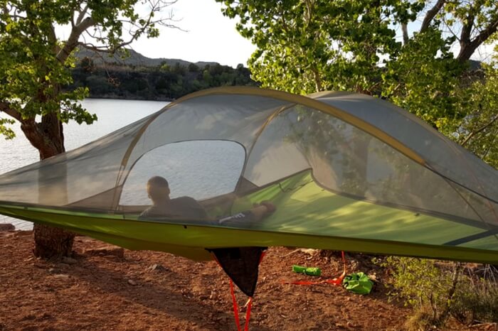 A traveler relaxing in a hammock tent