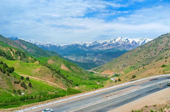 The road in Uzbekistan through greens and deserts