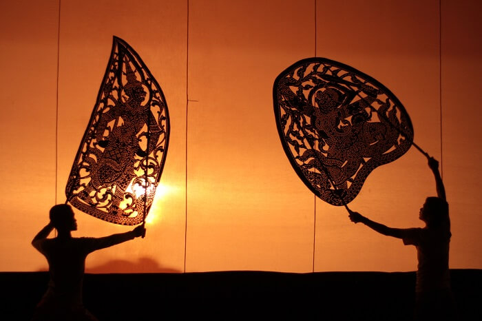 Two artists seen as shadows during one of the shadow puppetry performance in Cambodia