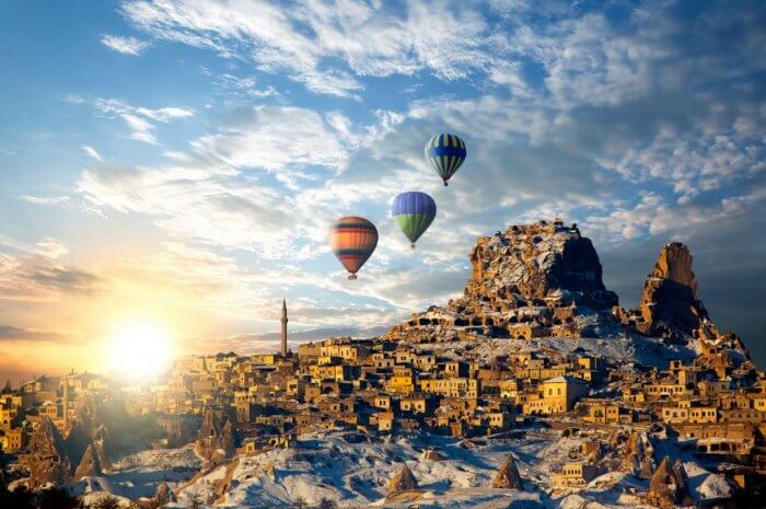 Hot air balloons sailing above the ruins and caves of Cappadocia