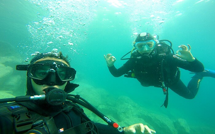 Two divers posing for photograph inside the ocean
