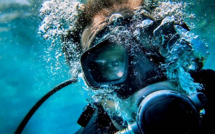 A scuba diver blowing bubbles under the sea