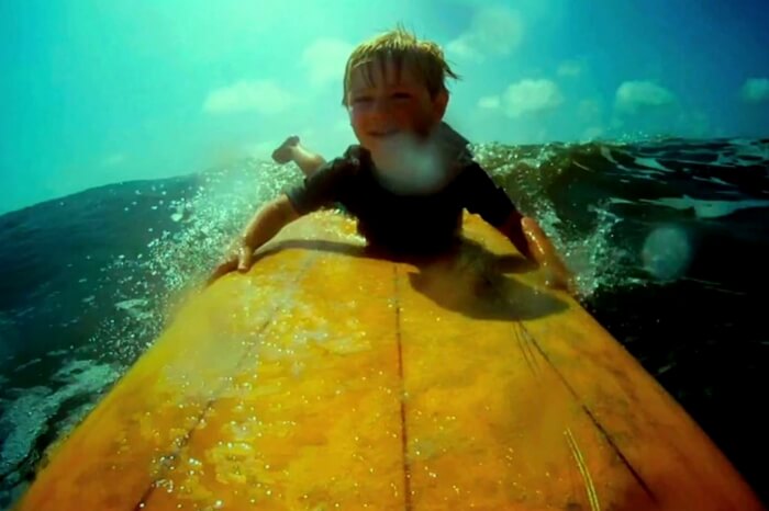 Child playing on waves in a still from the movie Life in a Day