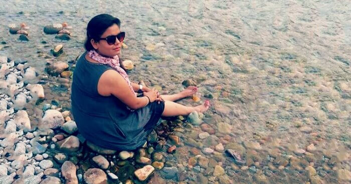 Nidhi sitting beside a stream in Jim Corbett