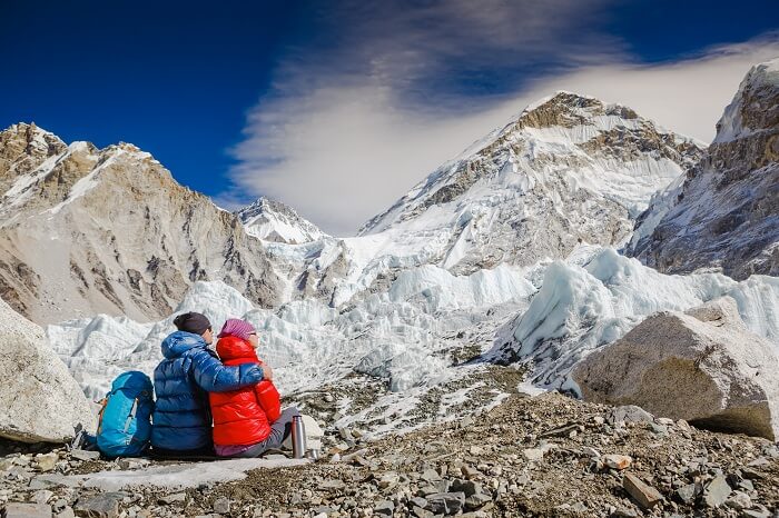 An adventurous couple enjoying the mountain view while trekking in Nepal