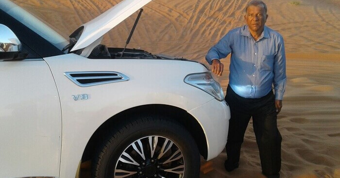 Sridhar infront of a car during his solo trip to Dubai