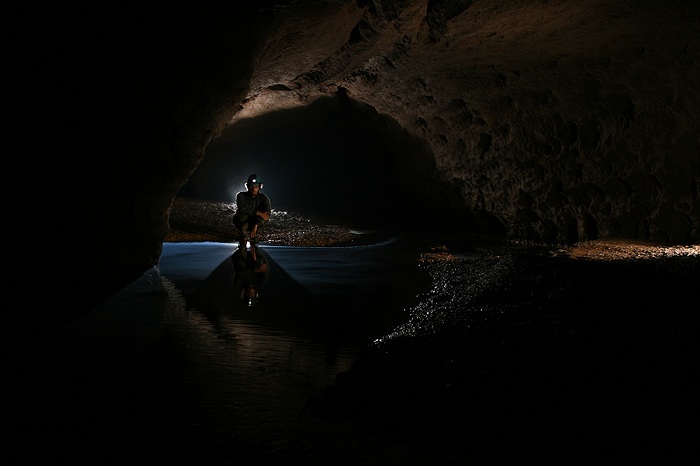 A cave explorer poses for a photograph at night at the Krem Liat Prah cave in India